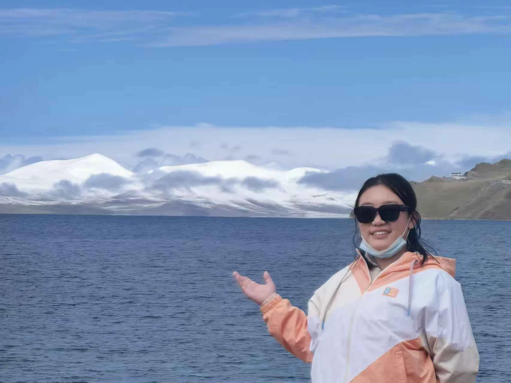 骆圳叶站在湖畔，背景为湖水与雪山